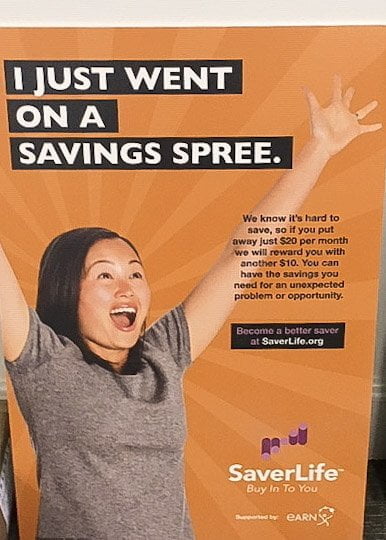 A SaverLife standee that says, "I just went on a savings spree."